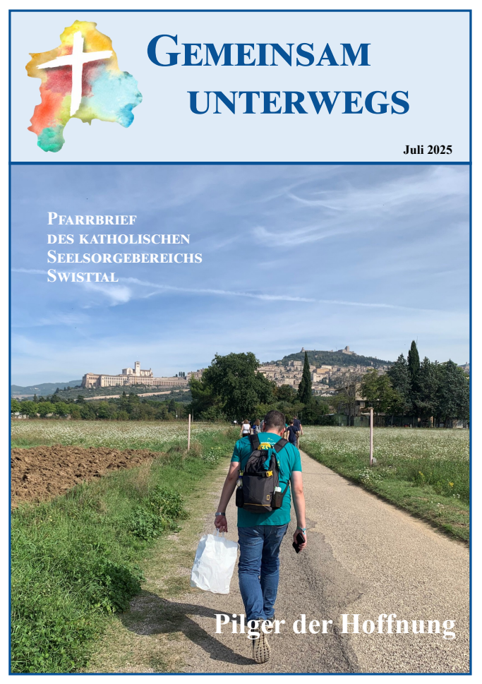 Wandernde Menschen von hinten auf einem Weg fotografiert, im Hintergrund eine hügelige Landschaft mit Häusern